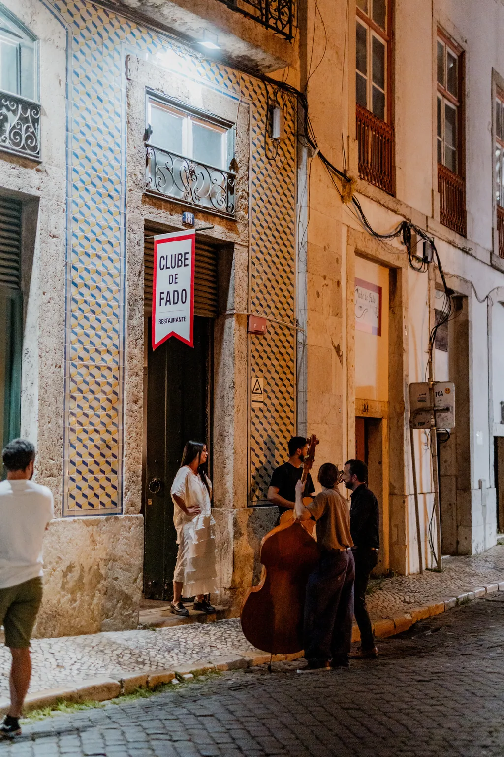 A fachada azulejada e a tabuleta na rua de Alfama