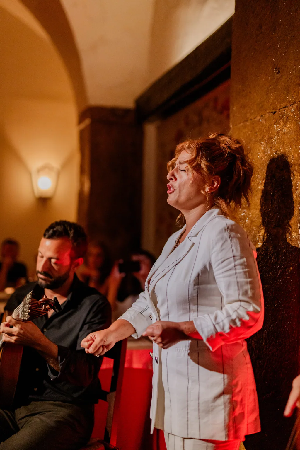 Clube de Fado — fadista cantando junto al arco dorado